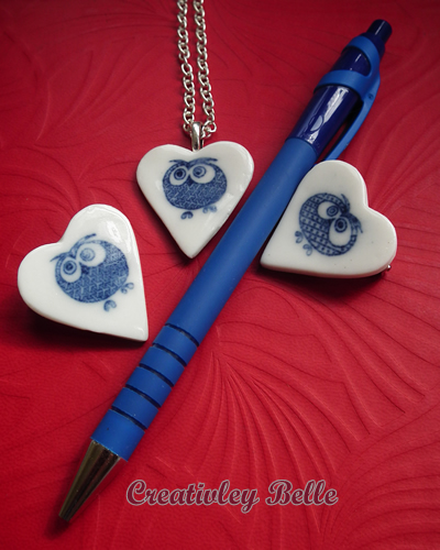 Size comparison for owl necklaces and pins with a pen
